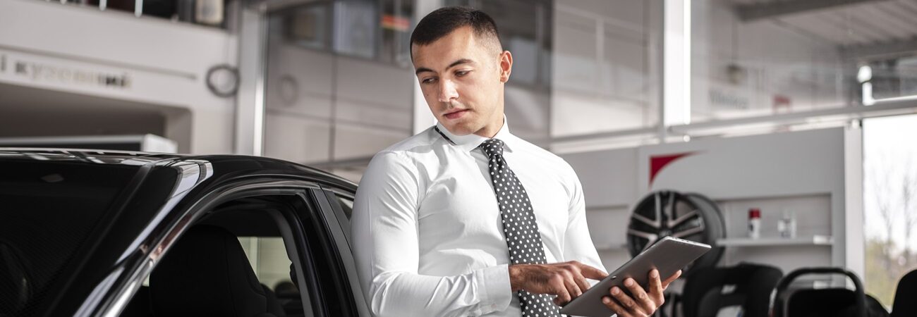 front-view-male-car-dealer-with-tablet